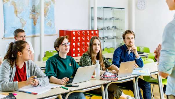 Studenten Zij-instroom luisteren tijdens een les naar de de docent.