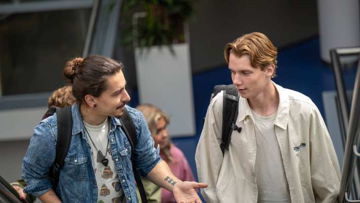 Twee jongens lopen door LvS10, gaan de trap op, al kletsend.