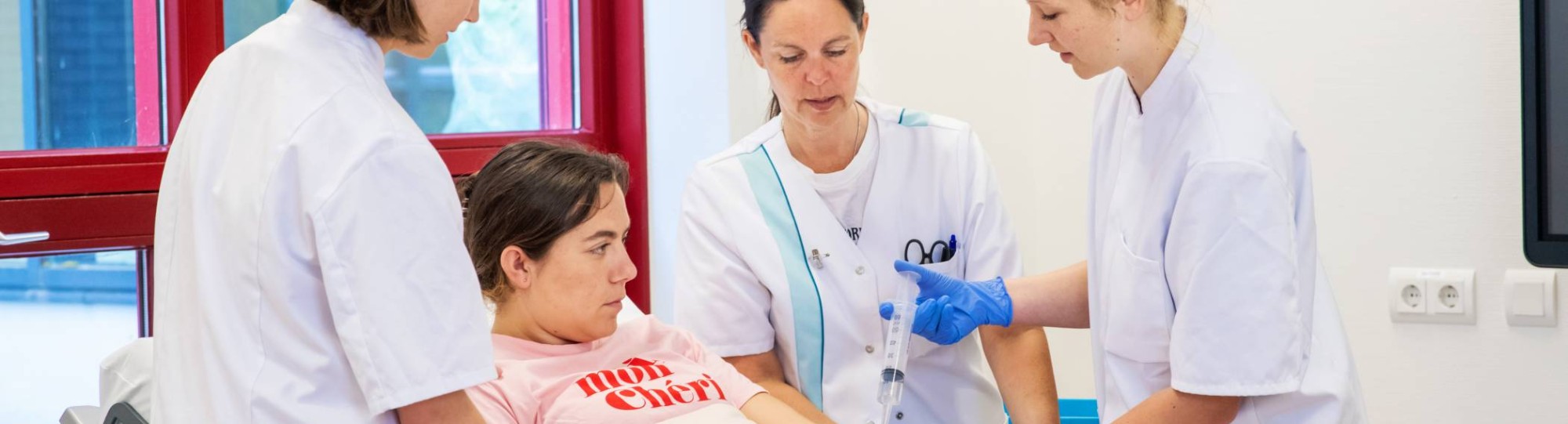 3 verpleegkundigen rondom het bed van een patiënt