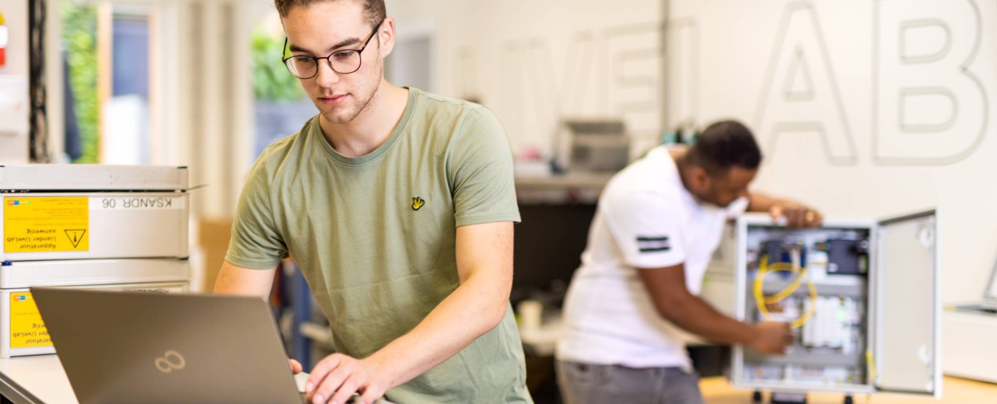 voltijdstudent Mik aan het werk op zijn laptop bij Qirion Alliander