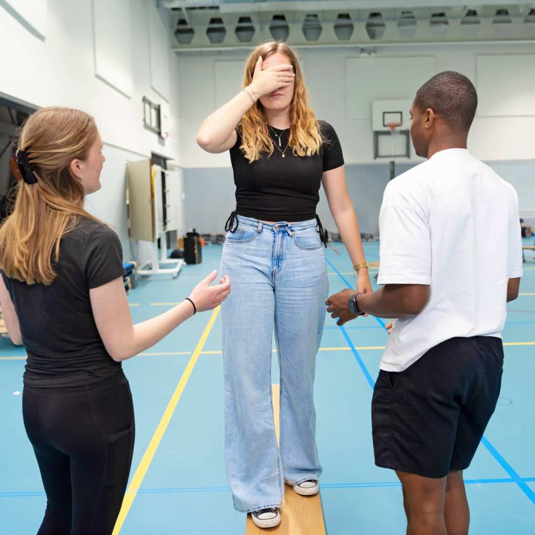 Studenten PMT doen een oefening tijdens les in gymzaal