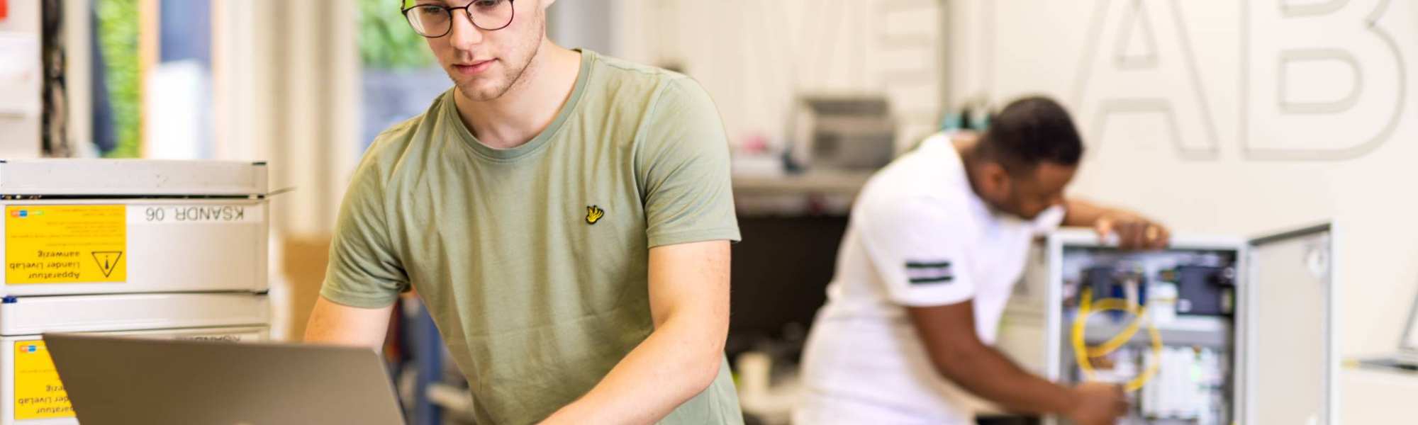voltijdstudent Mik aan het werk op zijn laptop bij Qirion Alliander