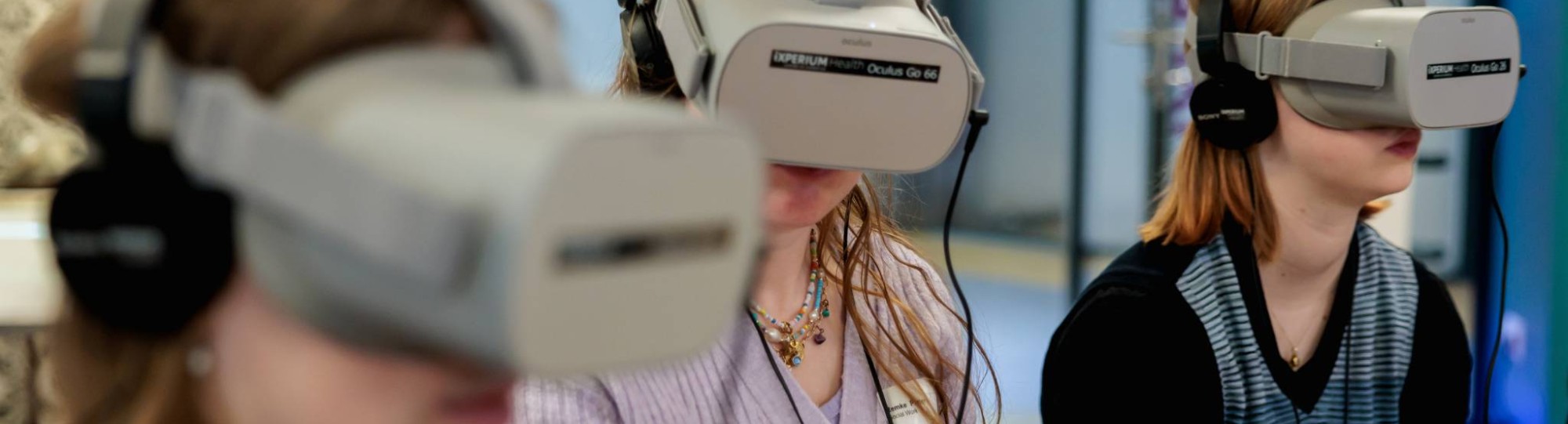 Drie vrouwen met een grijze virtual reality bril op 