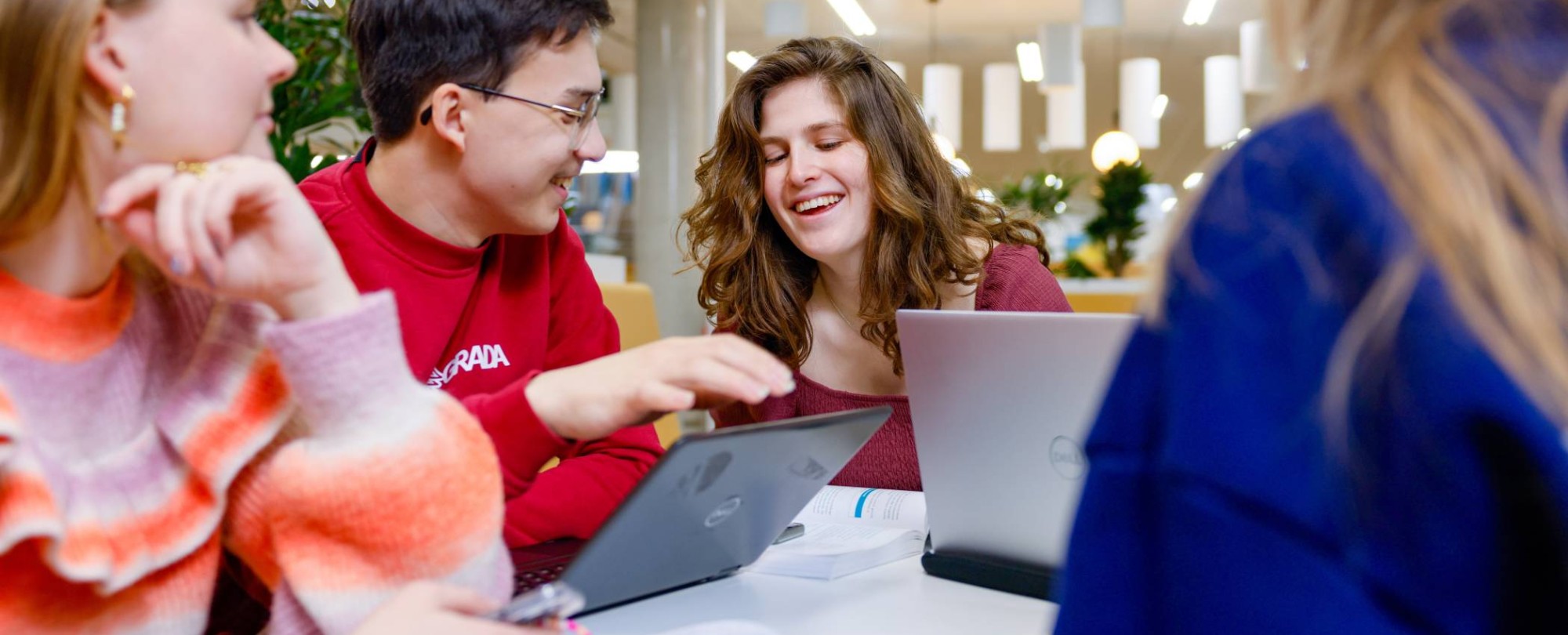 Studenten werken samen achter een laptop
