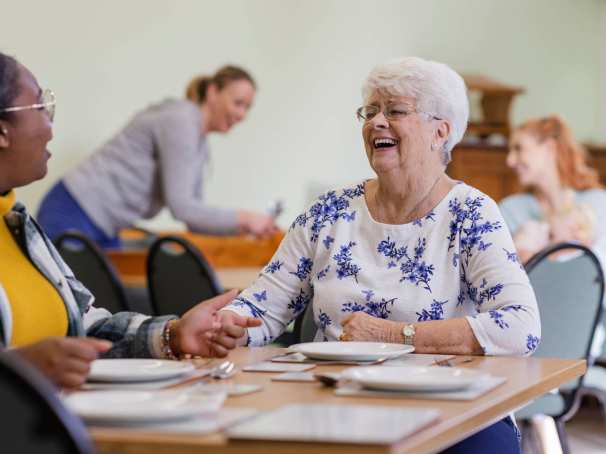 Lachende dame aan eettafel