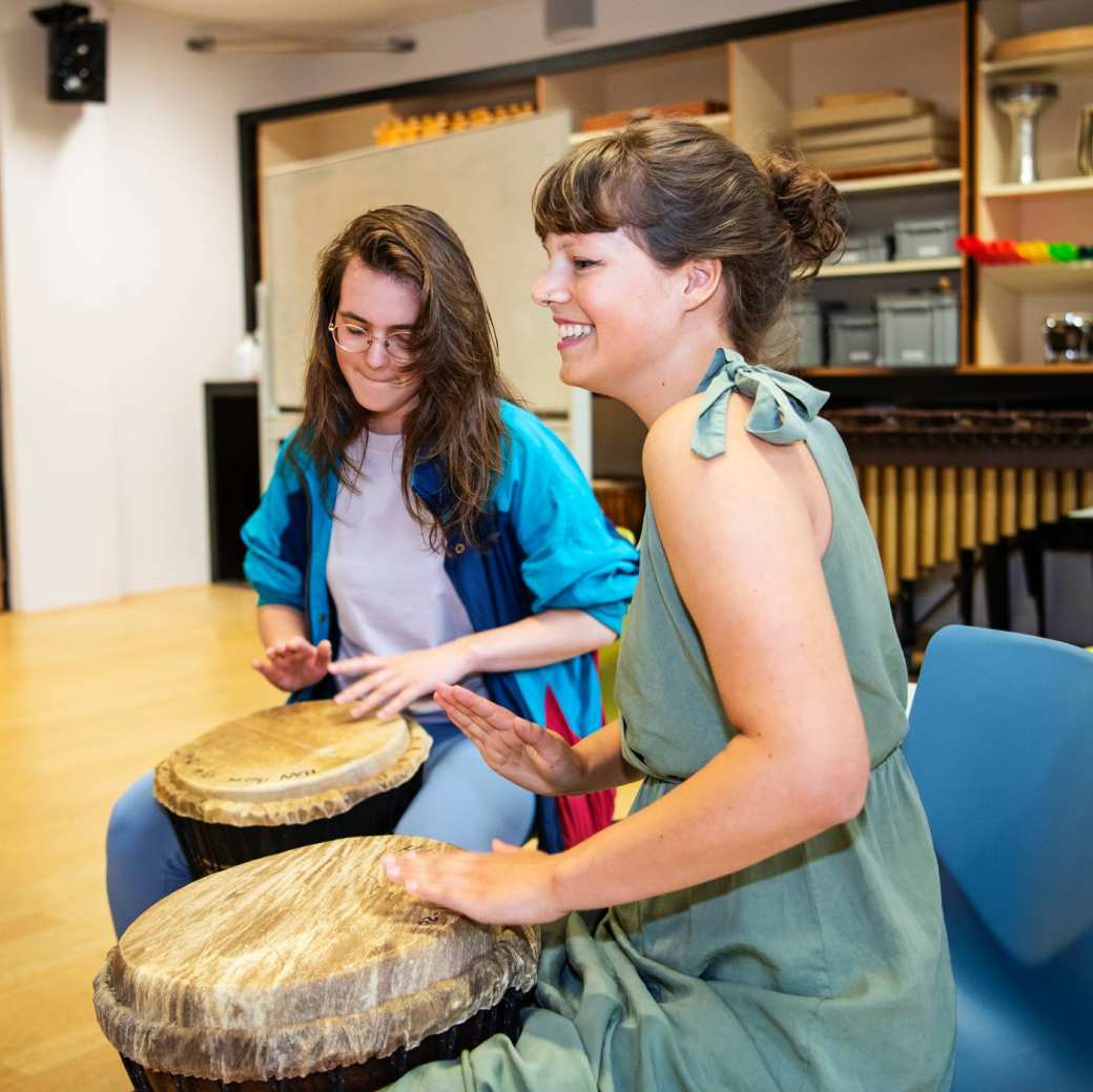 Twee medestudenten spelen samen op de djembe