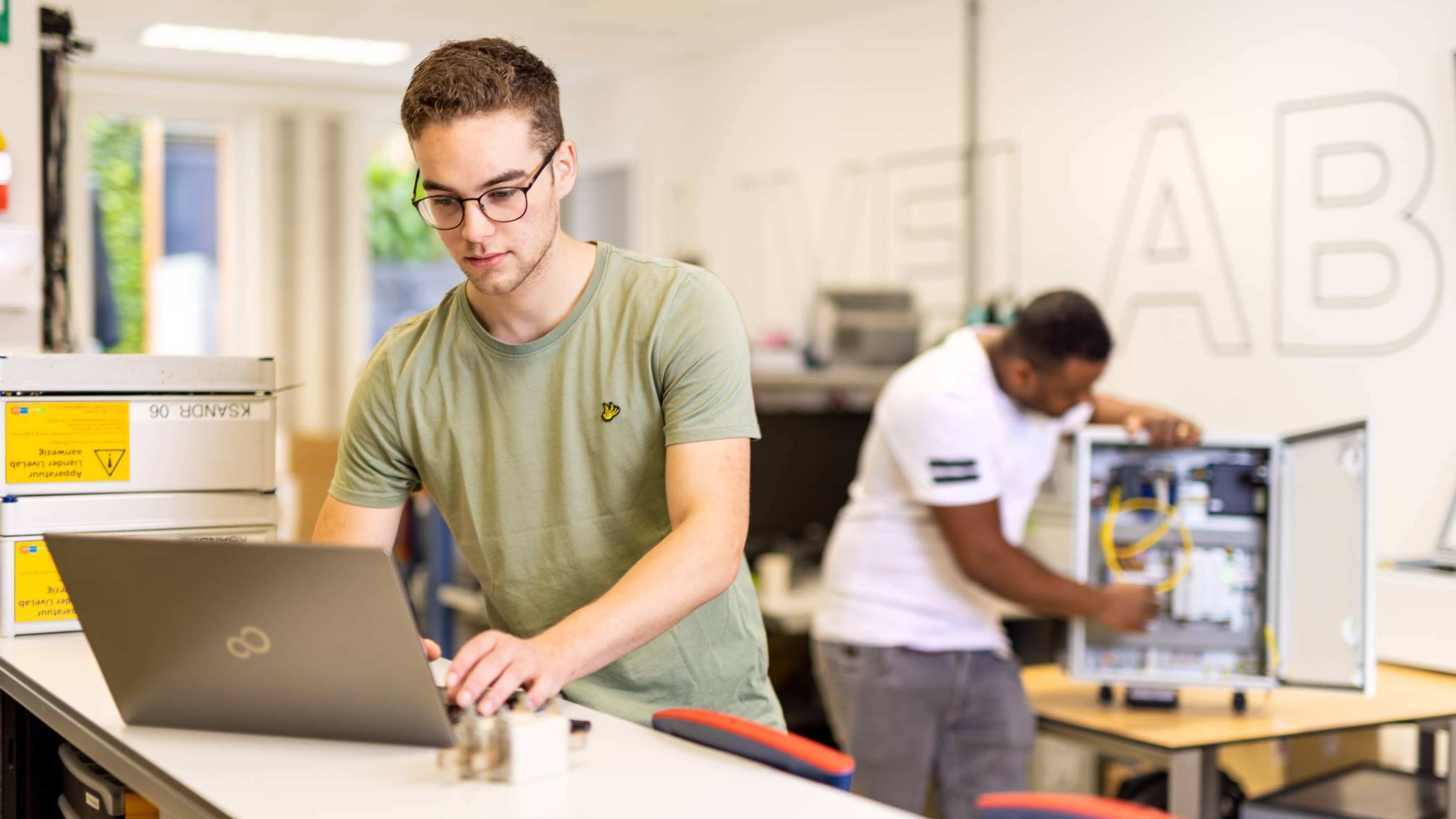 Elektrotechniekstudent Mik op kantoor bij Qirion samen met een collega
