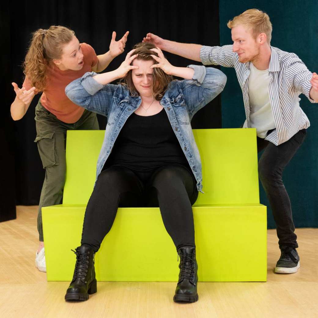 Drie studenten Dramatherapie doen een oefening waarbij ze veel emotie tonen tijdens een praktijkles