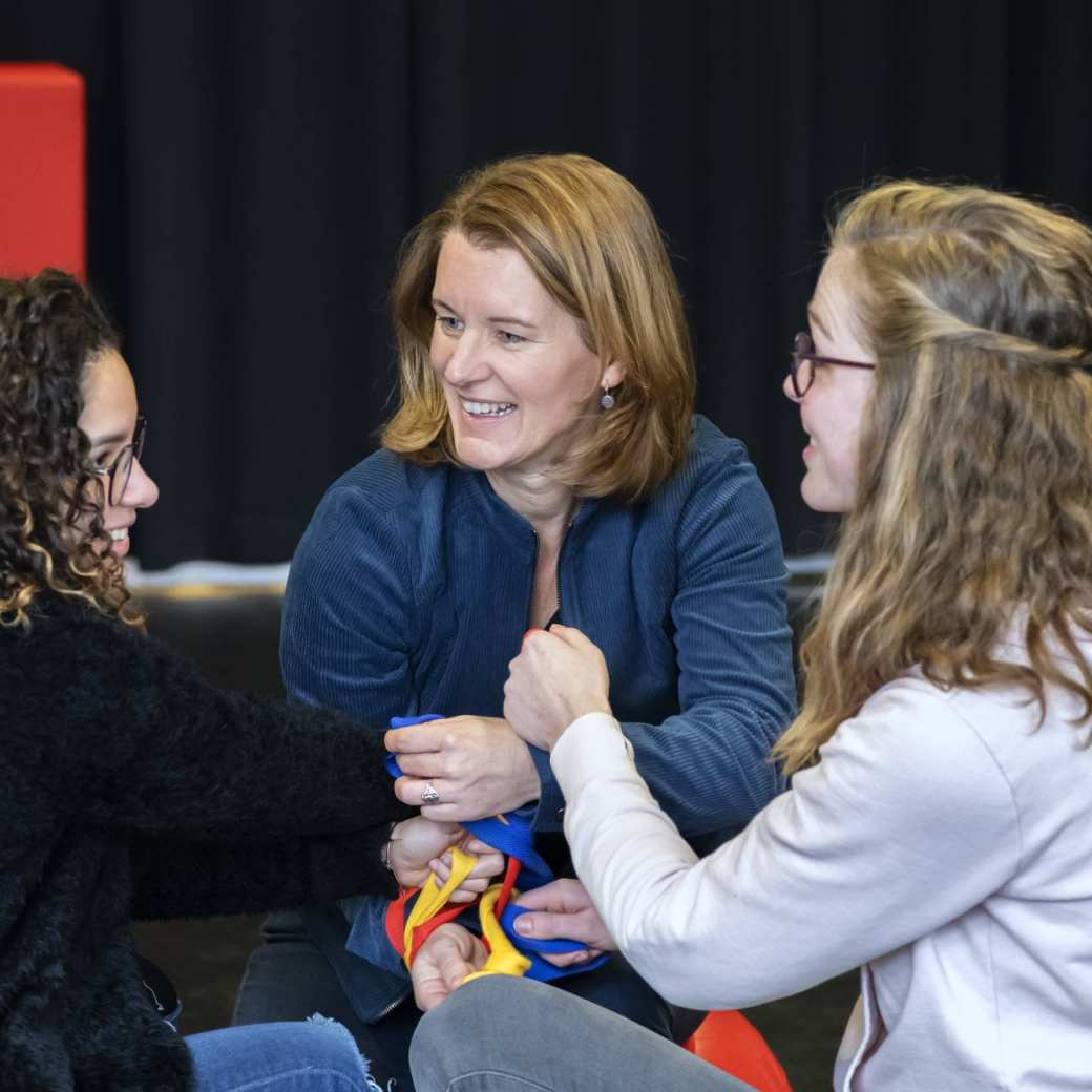 3 studenten van de han master vaktherapie psychomotorische therapie doen een oefening met een lint en skippyballen in de gymzaal