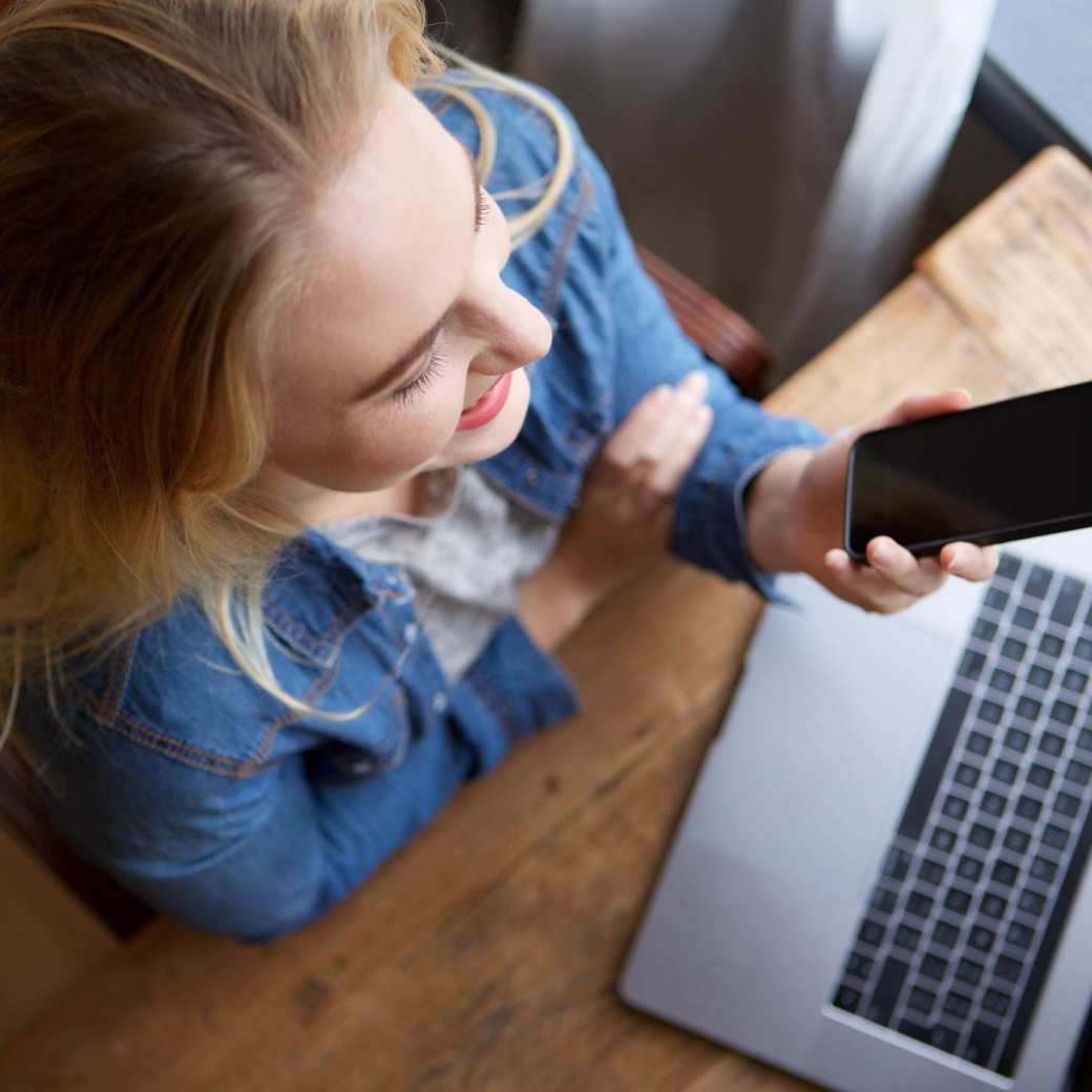 Stockfoto van vrouw met laptop en telefoon voor website Centrum Meervoudige Waardecreatie. 