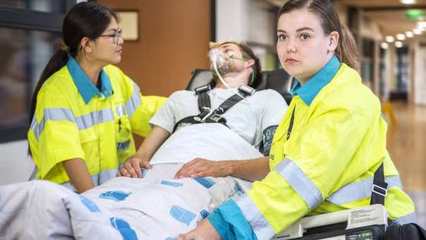 Studenten ambulance met simulatiepatiënt op brancard