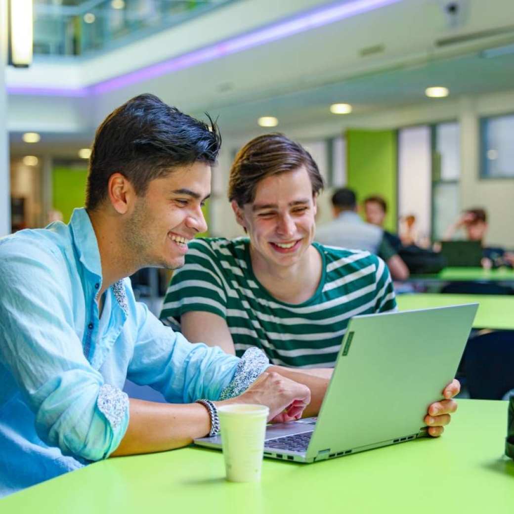 twee personen van Ondernemerschap & Retail Managementkijkende naar een laptop