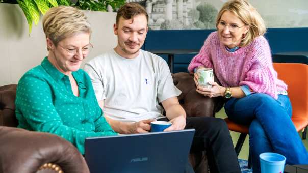 Drie studenten kijken op laptop