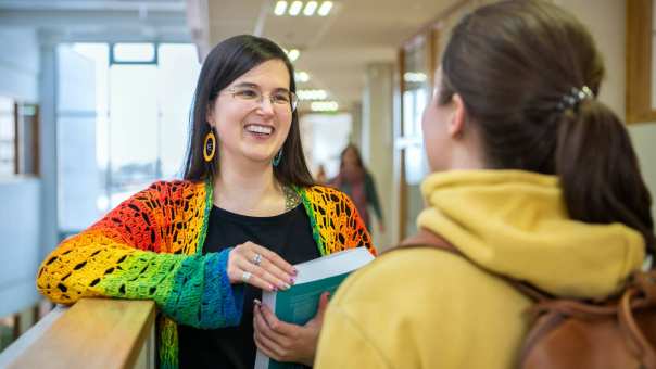 2 masterstudenten Leraar Nederlands met elkaar in gesprek op de gang,