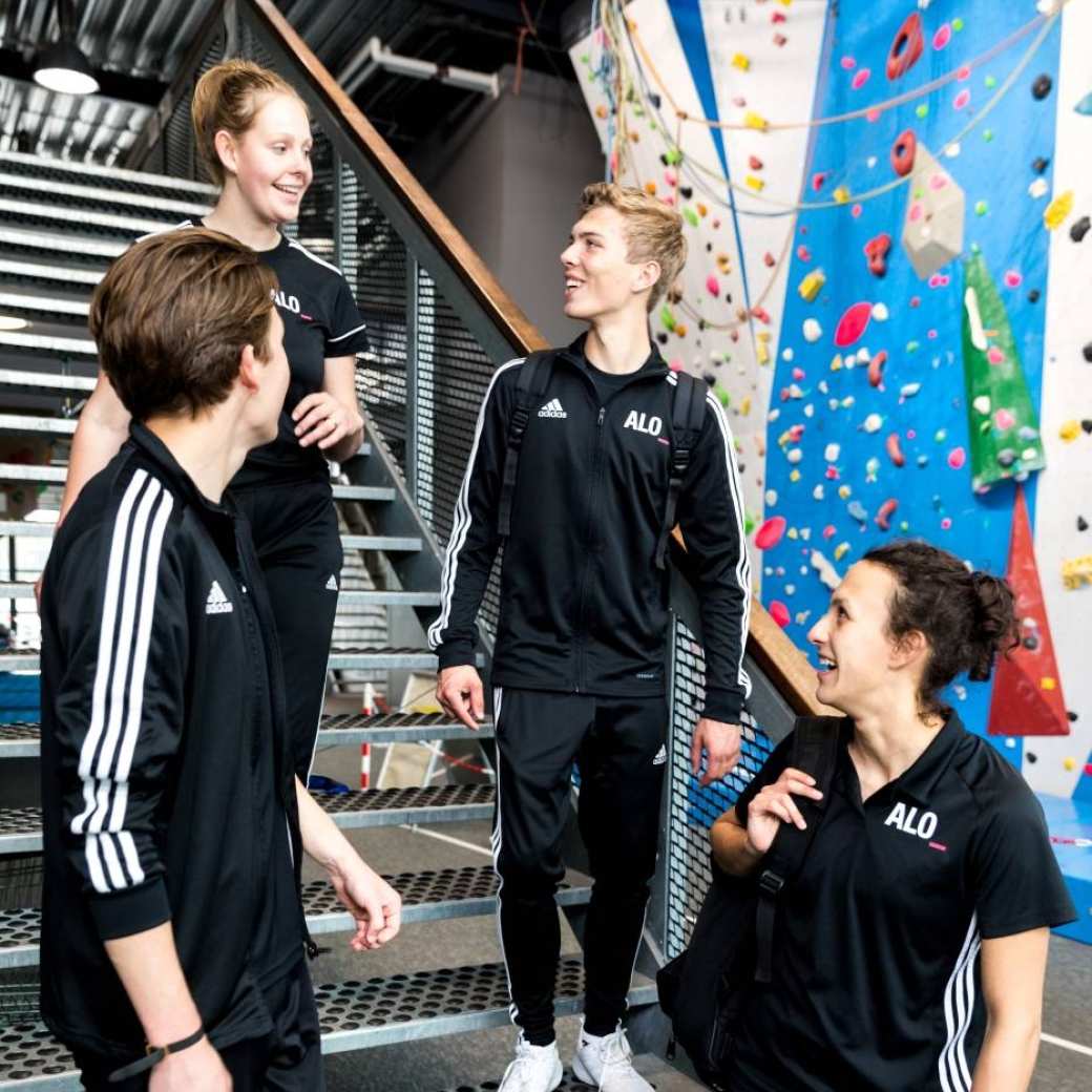 4 Pabo-ALO studenten staan op de trap te kletsen in hun ALO-outfit.