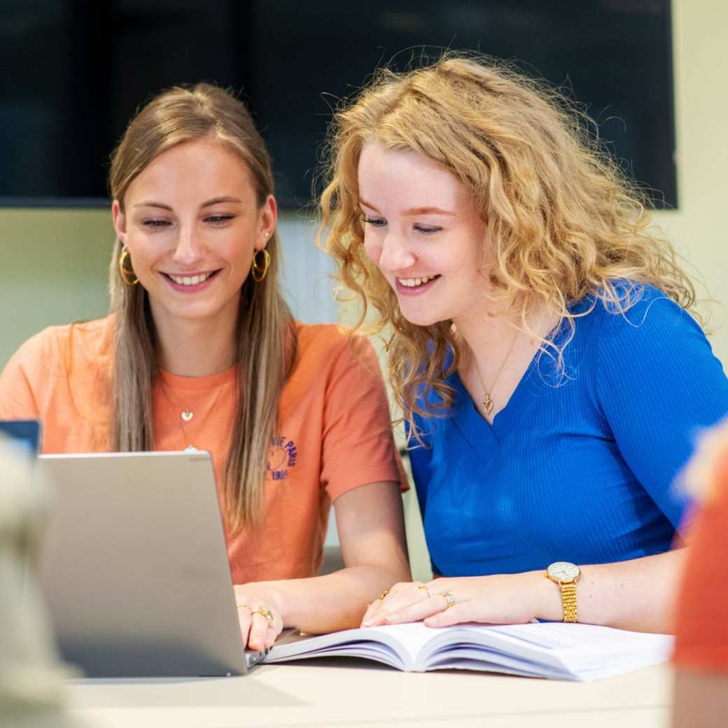 Twee Vaktherapie studenten werken samen achter een laptop