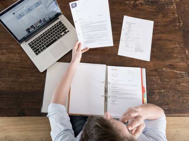 Man leest overheidsbrieven aan tafel