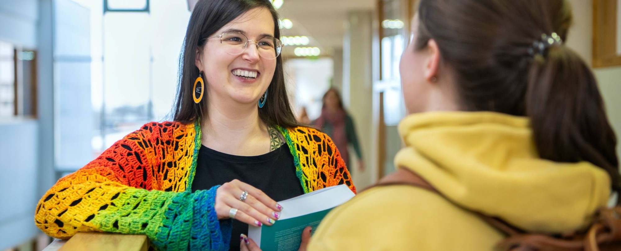 2 masterstudenten Leraar Nederlands met elkaar in gesprek op de gang,