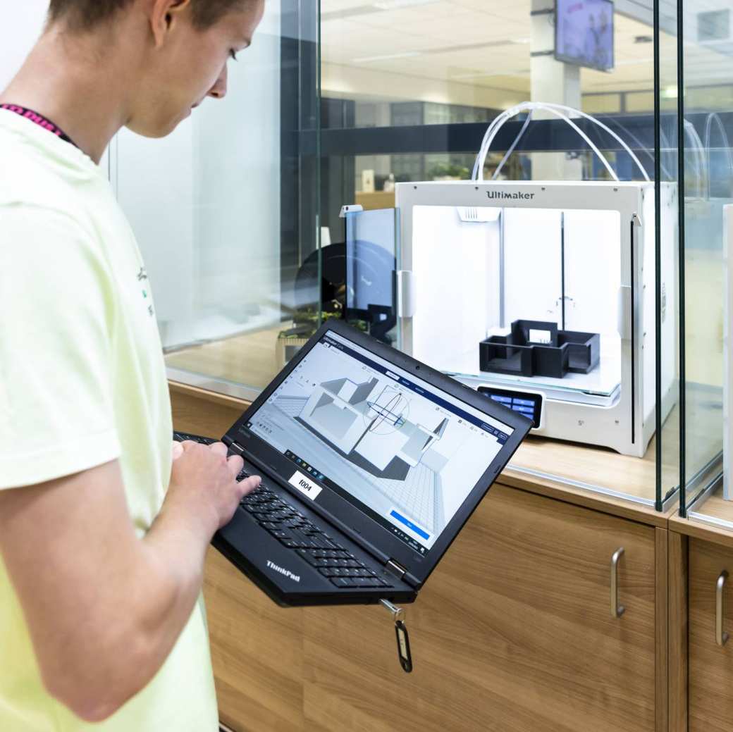 student bouwkunde met laptop bij 3d-printer