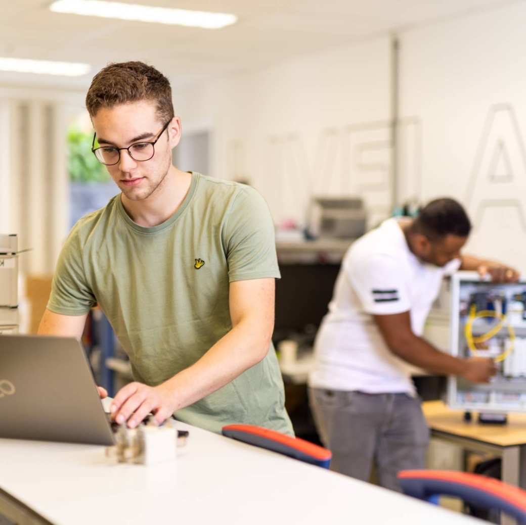 voltijdstudent Mik aan het werk op zijn laptop bij Qirion Alliander