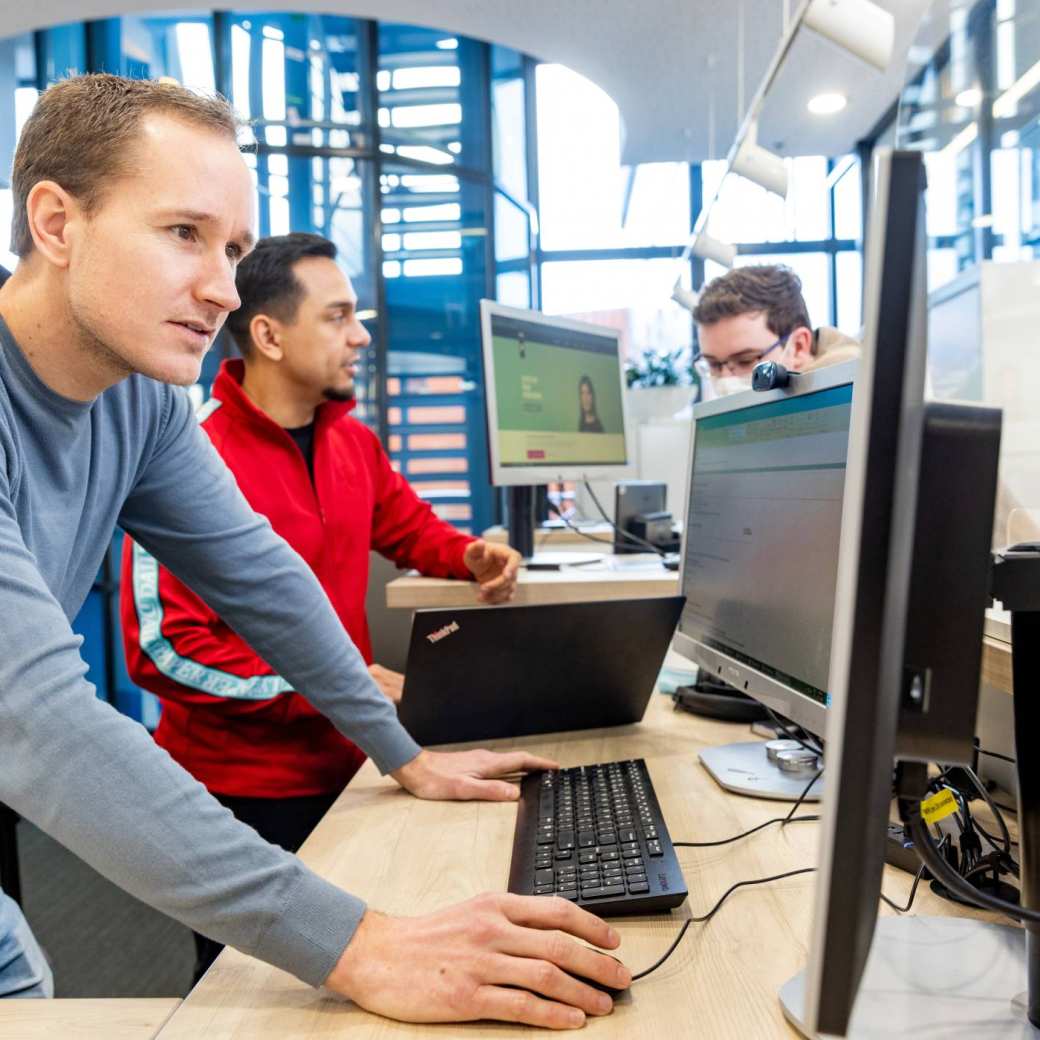 Ralph de Vaan en Lucas Muller Lima, medewerkers van ASKHAN, werken bij de balie op K33.